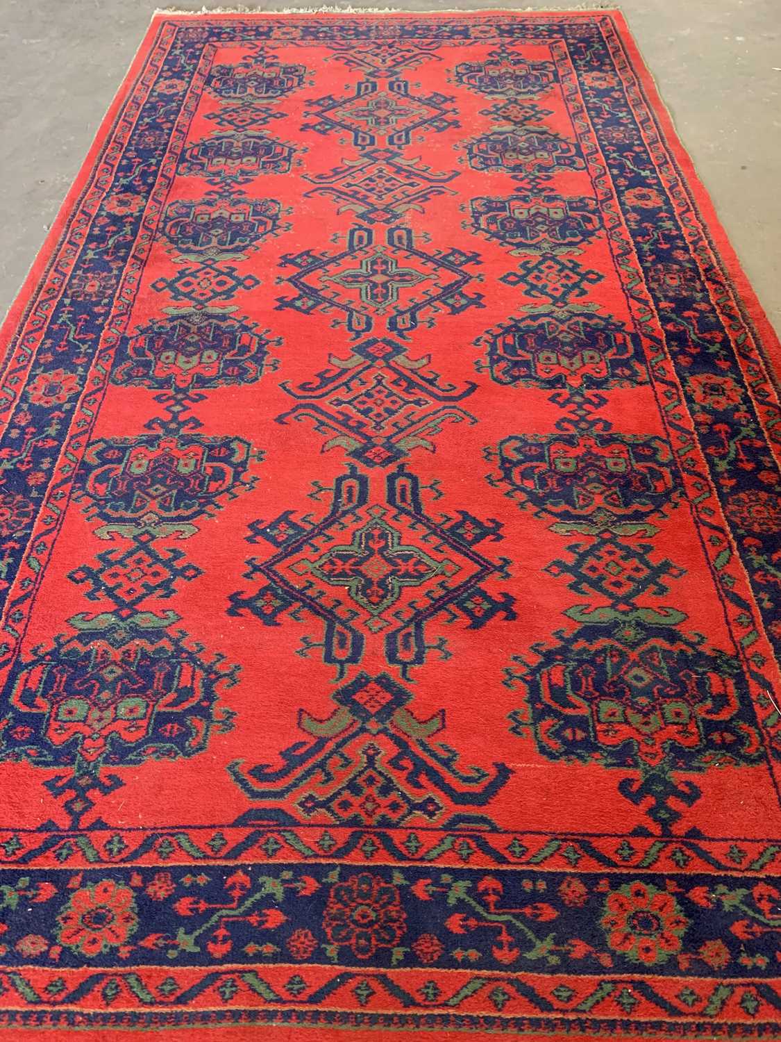 EASTERN STYLE WOOLLEN RUG, red and blue ground with repeating central pattern, 370 x 202cms