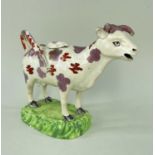 SWANSEA PEARLWARE COW CREAMER, typically decorated with lilac and iron red lustre, standing on a