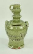 EWENNY POTTERY MONEY BOX in green glaze, applied rope-twist handles, finial in the form of a