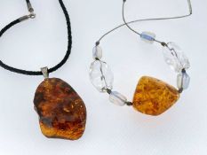 TWO BALTIC AMBER NUGGET PENDANTS, 5.4cms long and 3.5cms long (2)