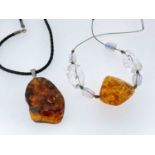 TWO BALTIC AMBER NUGGET PENDANTS, 5.4cms long and 3.5cms long (2)