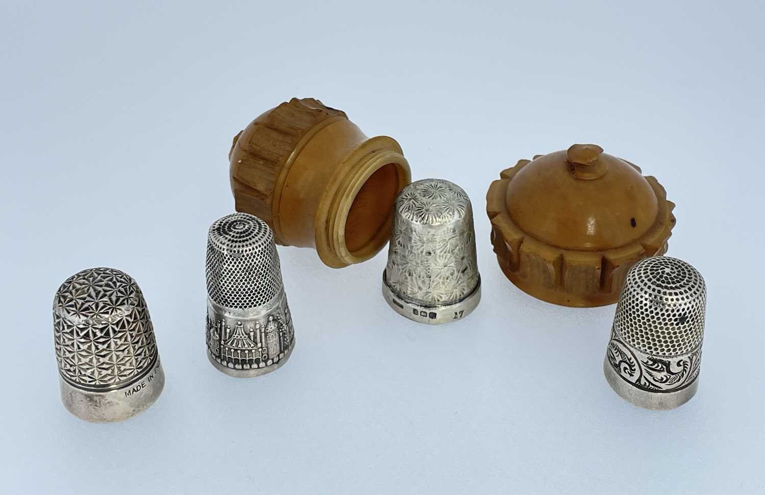 VEGETABLE IVORY THIMBLE CASE, together with four white metal thimbles, two hallmarked silver (5)