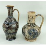 TWO DOULTON LAMBETH EWERS, both decorated with foliate motifs, the tallest having incised