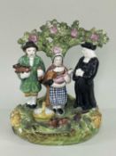 VICTORIAN STAFFORDSHIRE 'TITHE PIG' GROUP, figures standing before a bocage, 15 x 10.5cm Comment: