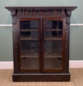 STAINED OAK TWO-DOOR GLAZED LOW-COUNTRY BOOKCASE, heavily carved with carved mask corbels, 115cms