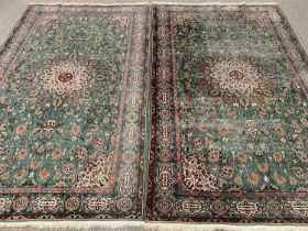 EASTERN TYPE RUGS, a pair, green ground with central motif and patterned border, 225 x 136cms