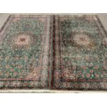 EASTERN TYPE RUGS, a pair, green ground with central motif and patterned border, 225 x 136cms