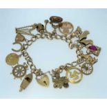 9CT GOLD CHARM BRACELET having 9ct gold heart padlock, sixteen 9ct gold charms including harp, speed
