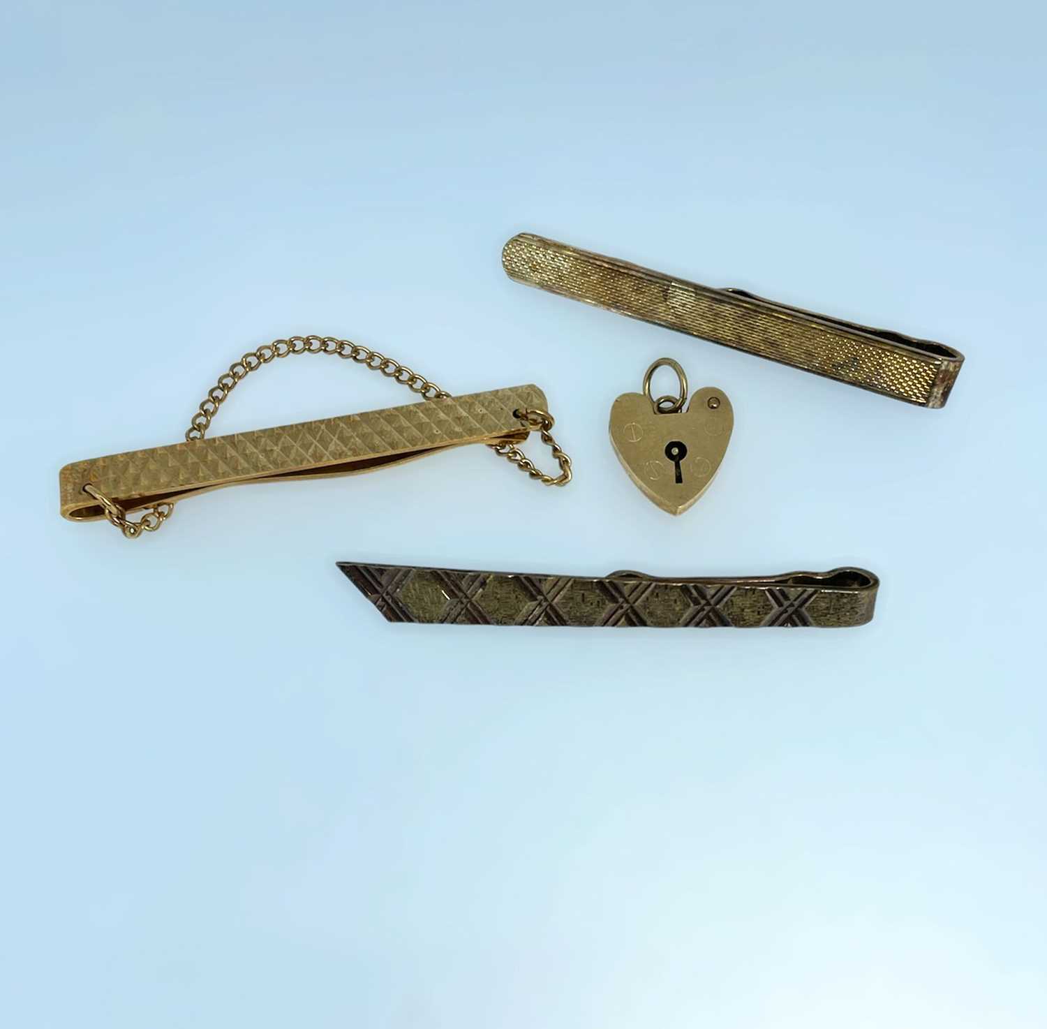 9CT GOLD TIE CLIP, 9ct gold heart shaped padlock (7.5gms overall), together with two silver gilt tie