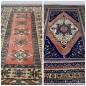 TWO TURKISH WOOLEN RUGS, one in pale blue, pink and beige, 205 x 128cms and the other in navy,