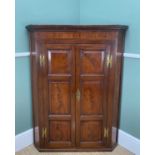 GEORGE III MAHOGANY HANGING CORNER CUPBOARD, moulded cornice over crossbanded frieze above triple