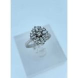 18CT WHITE GOLD DIAMOND CLUSTER RING, set with an arrangement of seventeen round and baguette cut