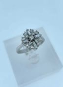 18CT WHITE GOLD DIAMOND CLUSTER RING, set with an arrangement of seventeen round and baguette cut