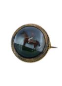YELLOW METAL HORSE RACING BROOCH, of circular form depicting jockey on horseback Provenance: private