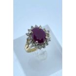 14K GOLD RUBY & DIAMOND HALO RING, the central ruby (11 x 9mms approx.) surrounded by sixteen (