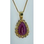 18K GOLD RUBY & DIAMOND PENDANT, the central cabochon pear shape ruby surrounded by sixteen