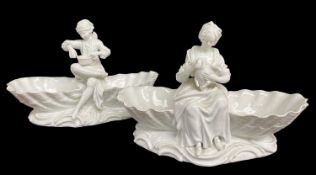 PAIR DRESDEN FIGURAL SWEETMEAT DISHES, a figure seated between clamshells on shsaped base, male
