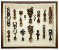 FRAMED GLASS DISPLAY OF LATER LOVESPOONS, decorated with carved daffodils, Welsh dragon, musical