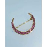 9CT GOLD RUBY CRESCENT BROOCH, set with nineteen graduated rubies, 3.2gms Provenance: private