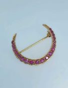 9CT GOLD RUBY CRESCENT BROOCH, set with nineteen graduated rubies, 3.2gms Provenance: private