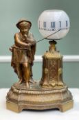 FRENCH NOVELTY LAMP CLOCK, gilt spelter figure of a youth with cane beside opaque glass rotating