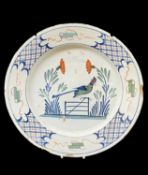 18TH CENTURY ENGLISH DELFT POLYCHROME DISH, probably Bristol c. 1750, naively painted with bird on a