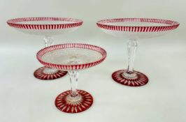 THREE FROSTED & RED OVERLAID GLASS TAZZE, with Greek key decoration and star-cut base, pair 25cms