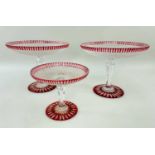 THREE FROSTED & RED OVERLAID GLASS TAZZE, with Greek key decoration and star-cut base, pair 25cms