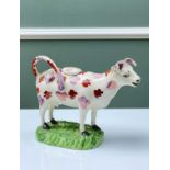 SWANSEA POTTERY COW CREAMER with pink lustre and red mottled markings, moulded base in bright