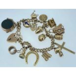 9CT GOLD CURB LINK CHARM BRACELET, having heart shaped padlock, twelve 9ct gold charms, one 15ct