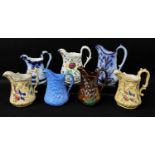 GROUP OF WELSH POTTERY MEDIUM SIZED MOULDED JUGS including Ynysmeudwy 'Triple Cherub', copper-