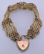 9CT GOLD GATE LINK BRACELET - with heart shaped locket, 21.6grms