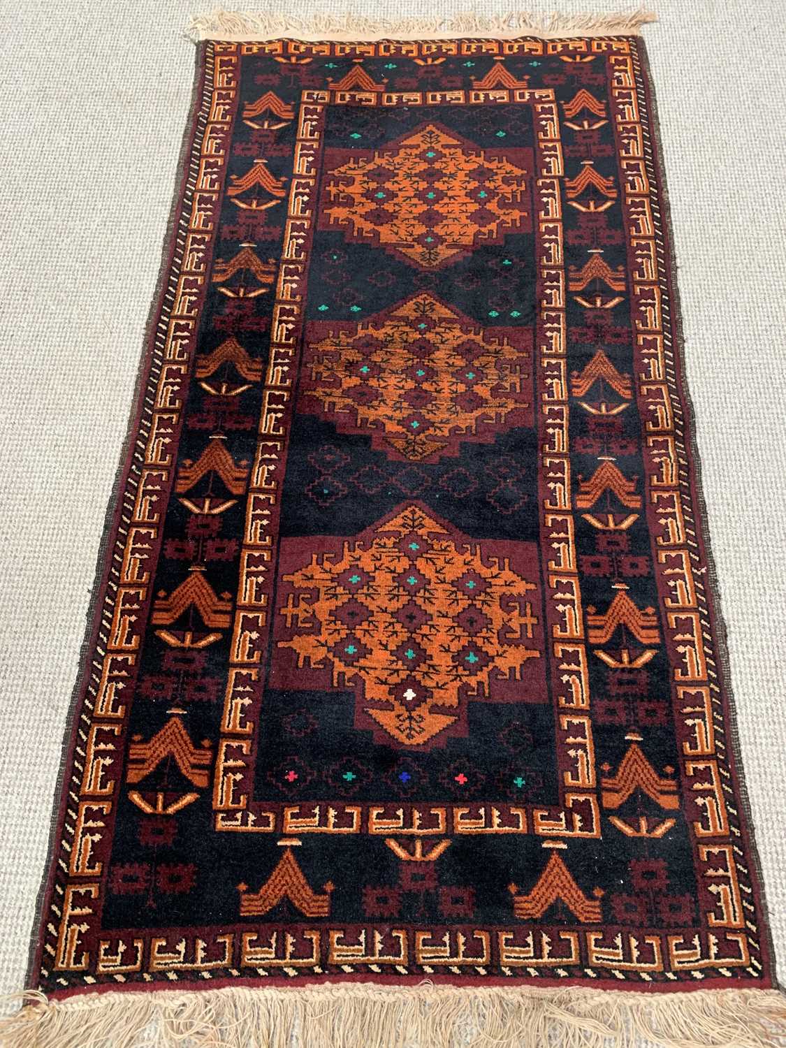 EASTERN RUG - various blues and reds ground with tasselled ends and triple diamond central