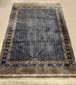 EASTERN TYPE WOOLLEN RUG - with tasselled ends, multiple border and gridded pattern diamond