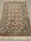 EASTERN TYPE RUG - terracotta ground with tasselled ends, wide bordered edge and repeating diamond