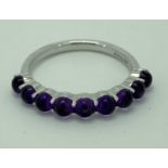 9CT WHITE GOLD & AMETHYST HALF ETERNITY RING - having 9 cabochon claw mounted stones, Size Mid M-