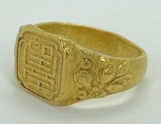 CHINESE 24CT GOLD RING - having Shou-character mark panel to the top and raised floral pattern sh