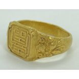 CHINESE 24CT GOLD RING - having Shou-character mark panel to the top and raised floral pattern sh