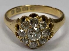 18CT GOLD DIAMOND CLUSTER DRESS RING - having a small centre diamond, visual estimate, 0.4ct with