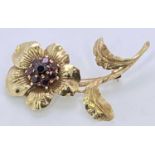 FINE GOLD PIN BROOCH - with a flower having a centre cluster of tiny rubies, gold mark indistinct (
