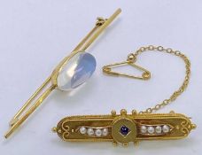 15CT GOLD BAR BROOCH, with safety chain and pin and having a centre small amethyst with four