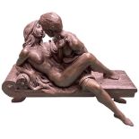 A modern bronzed resin sculpture of lovers on a Chaise Longue, signed R Cameron '00