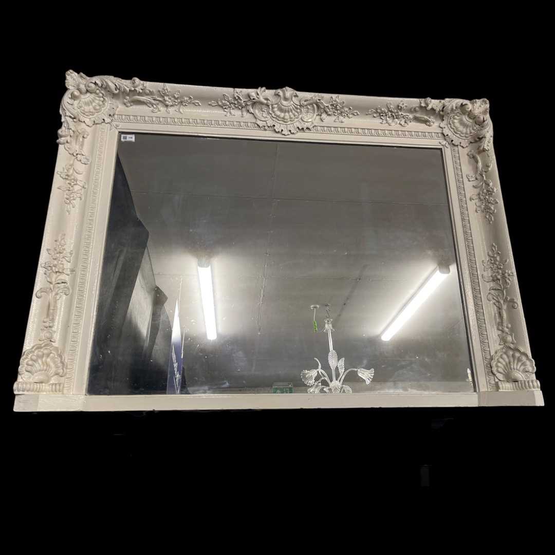 An Overmantle Mirror standing on 2 claw & ball feet, with ornate surround foliate detail.