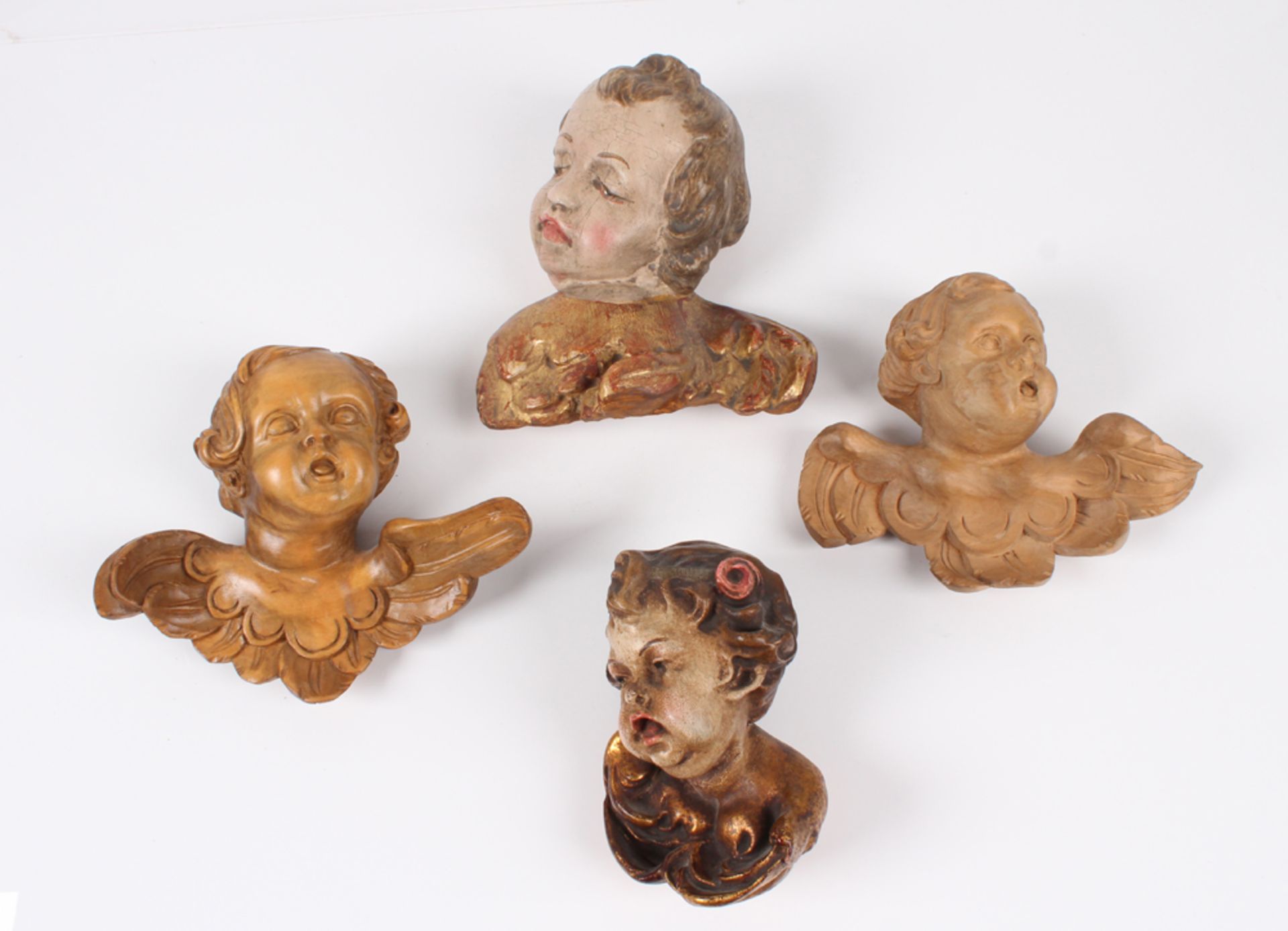 Vier Putti. Holz geschnitzt, teils