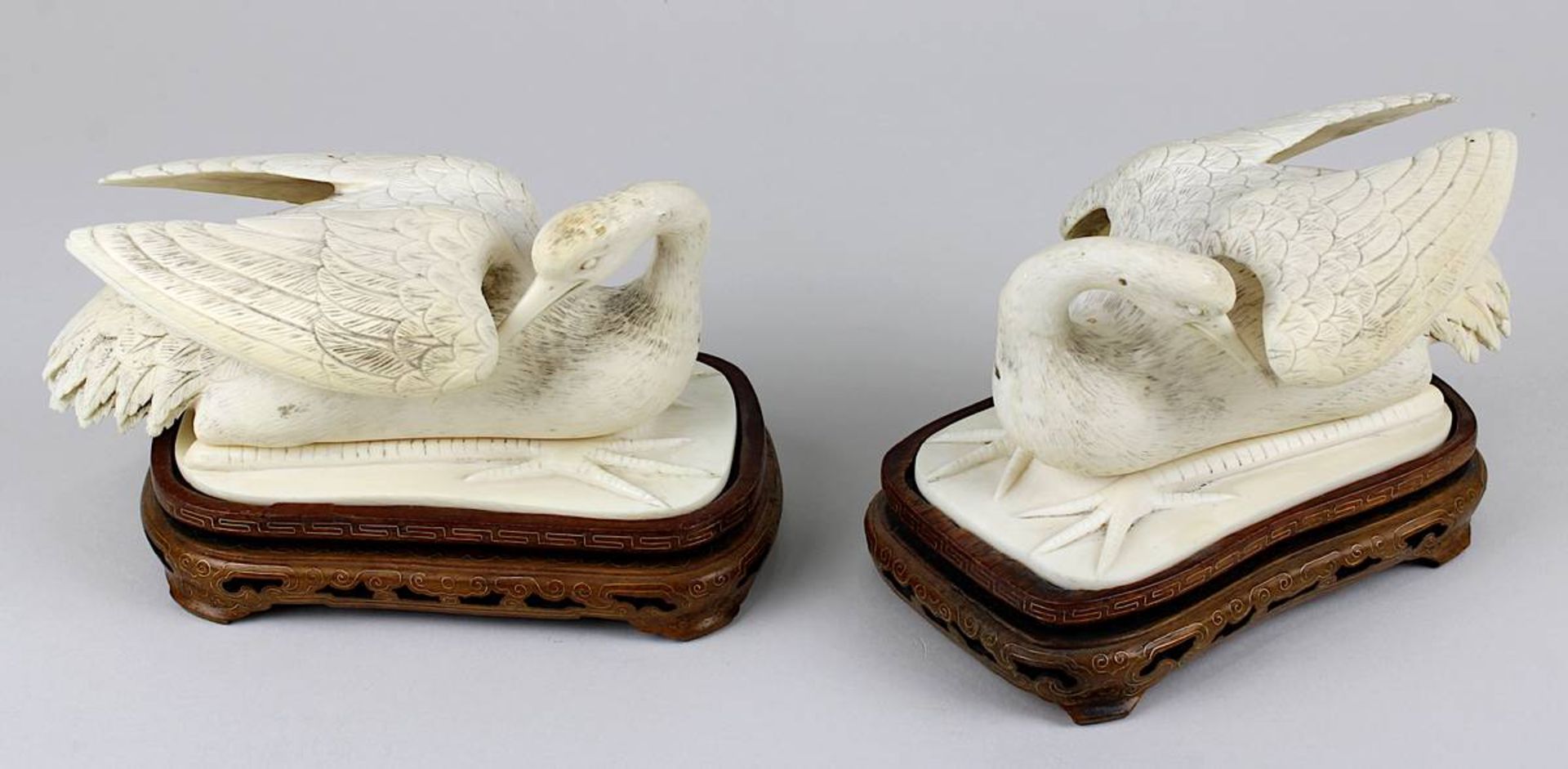 Paar liegende Reiher, Elfenbein, China 1. H. 20. Jh., jeweils zweiteilig, mit fein beschnitztem