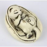 Elfenbein-Netsuke in Katzenform, Japan Anfang 20. Jh., sich in eine Decke kuschelndes Kätzchen,