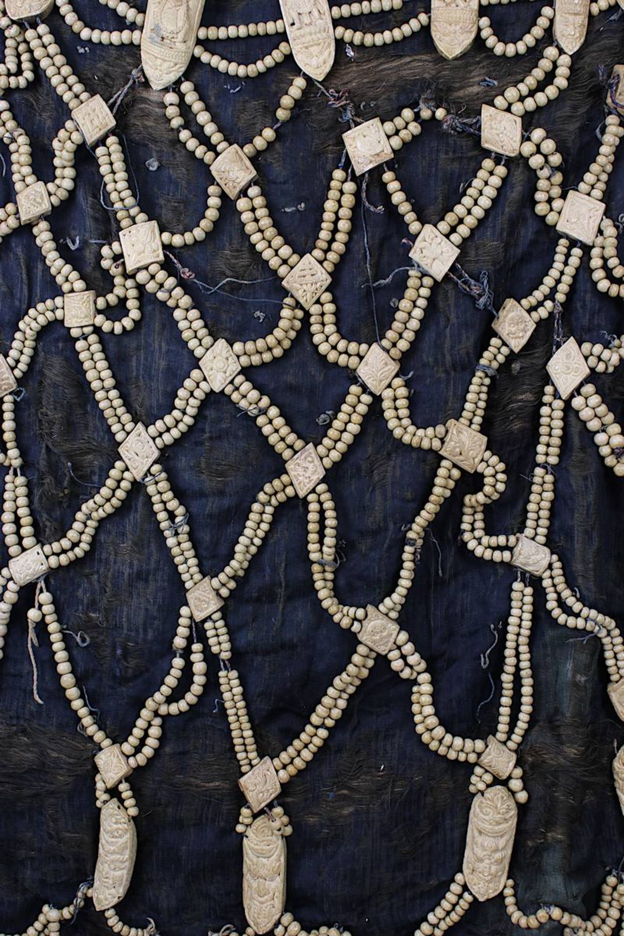 Knochenschürze, Tibet, wohl 19. Jh., dunkler Stoff, mit Netzwerk aus Knochenperlen u. Amuletten in - Bild 5 aus 5