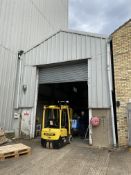 Atcost CONCRETE FRAMED BUILDING, approx. 14.7m x 5.6m x 5.3m high to eaves, with roller shutter door