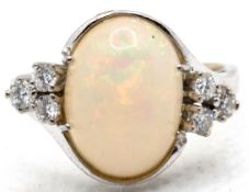 Ring, 585er WG, besetzt mit ovalem Opal-Cabochon und 6 seitlichen Brillanten von zus. 0,30 ct. (pun