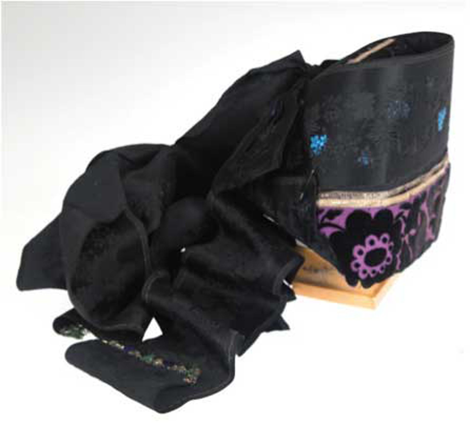 Trachtenkappe, schwarzer Stoff, Kappenrand lilafarben mit schwarzen Blüten, rückseitig Schleife und